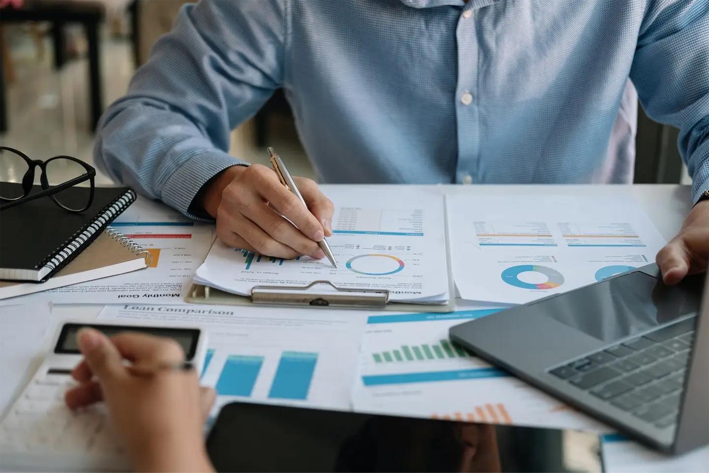 Close up businessman and partner using calculator and laptop for calculating finance tax